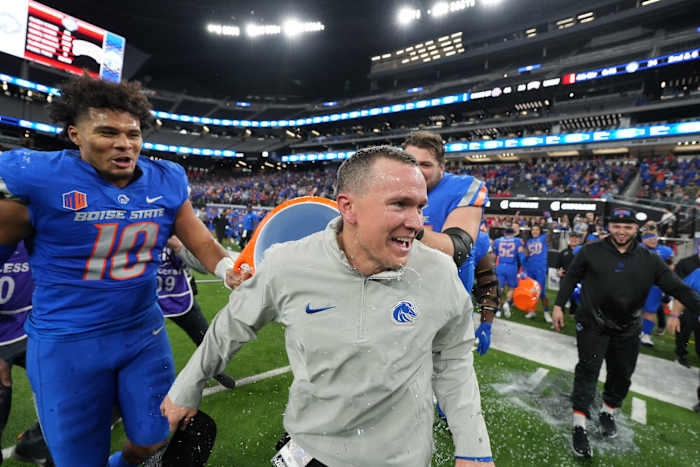 Spencer Danielson runs as Boise State players lift a gatorade cooler to dump on him